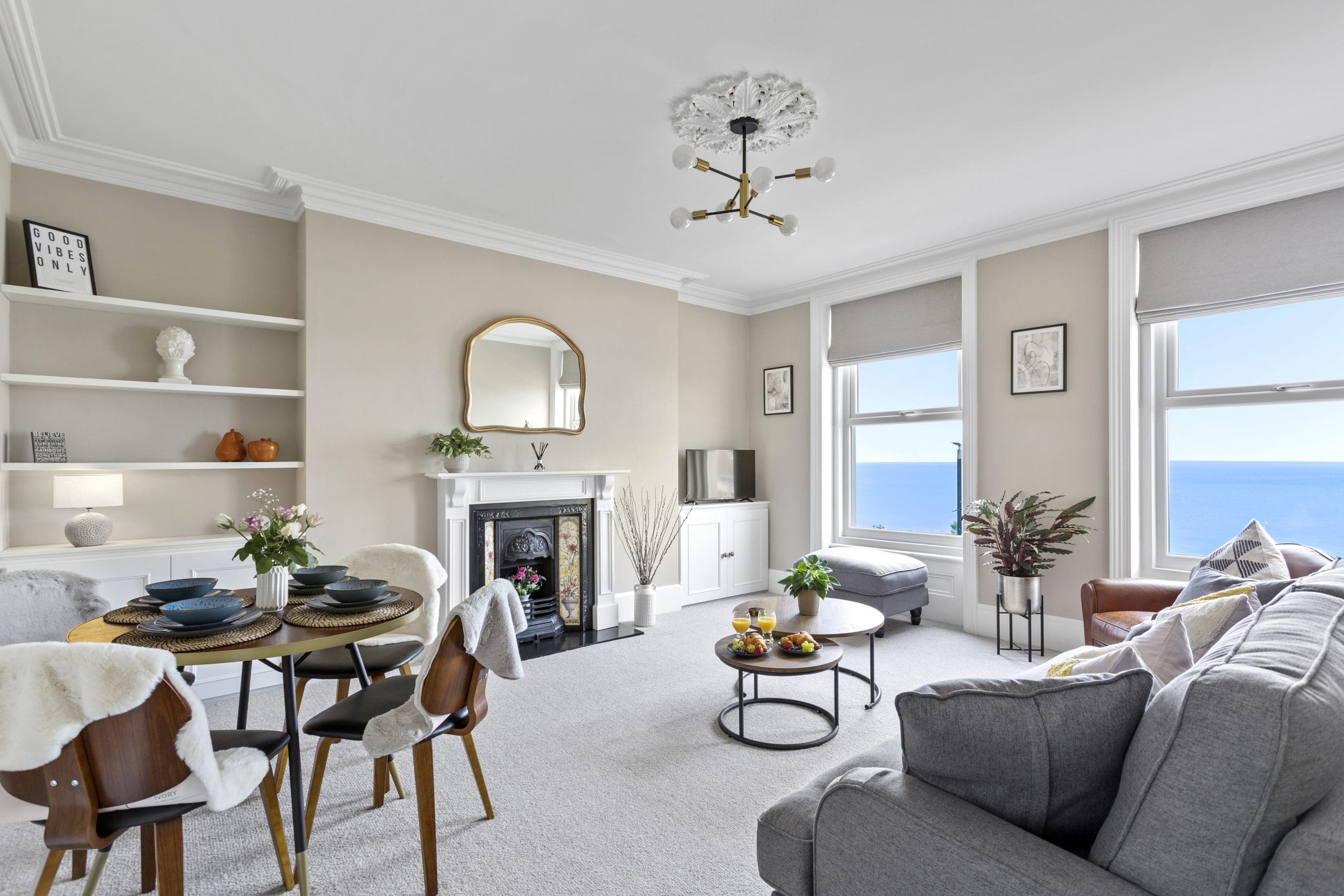 An image of a flat in Kent, you can see the sea just outside of the window. This is rented out for short-term rental or long-term rental by the property owner. The apartment is bright and spacious with a lounge filled with neutral but cosy tones.