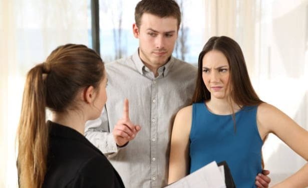 Bad real estate agent attending to discontent customers in a house interior